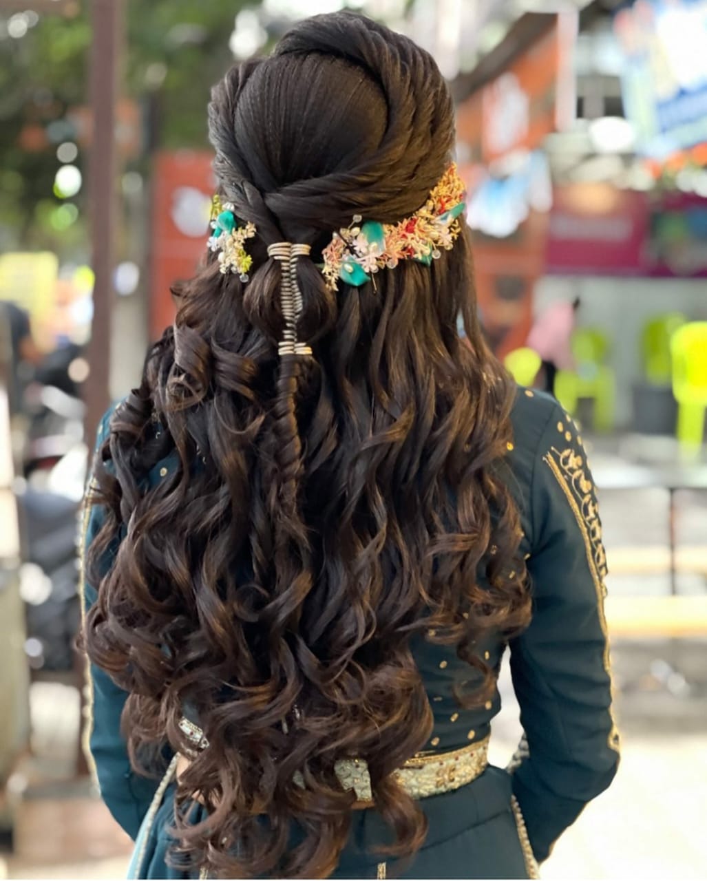 Half-tied open curls with a floral hair accessory styled at Prayosha Salon
