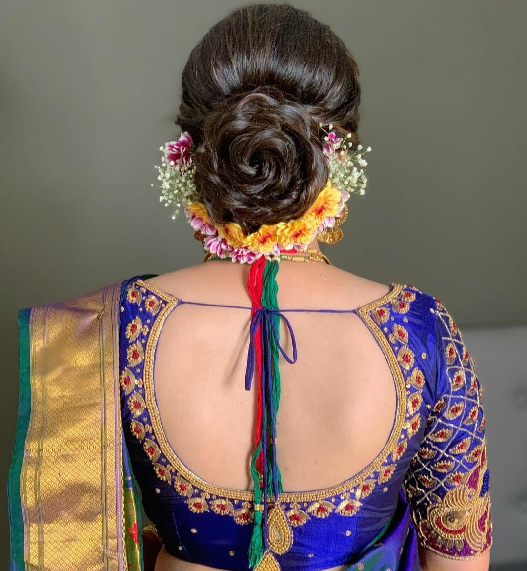 Rose-shaped bridal bun with fresh floral garland styled at Prayosha Salon