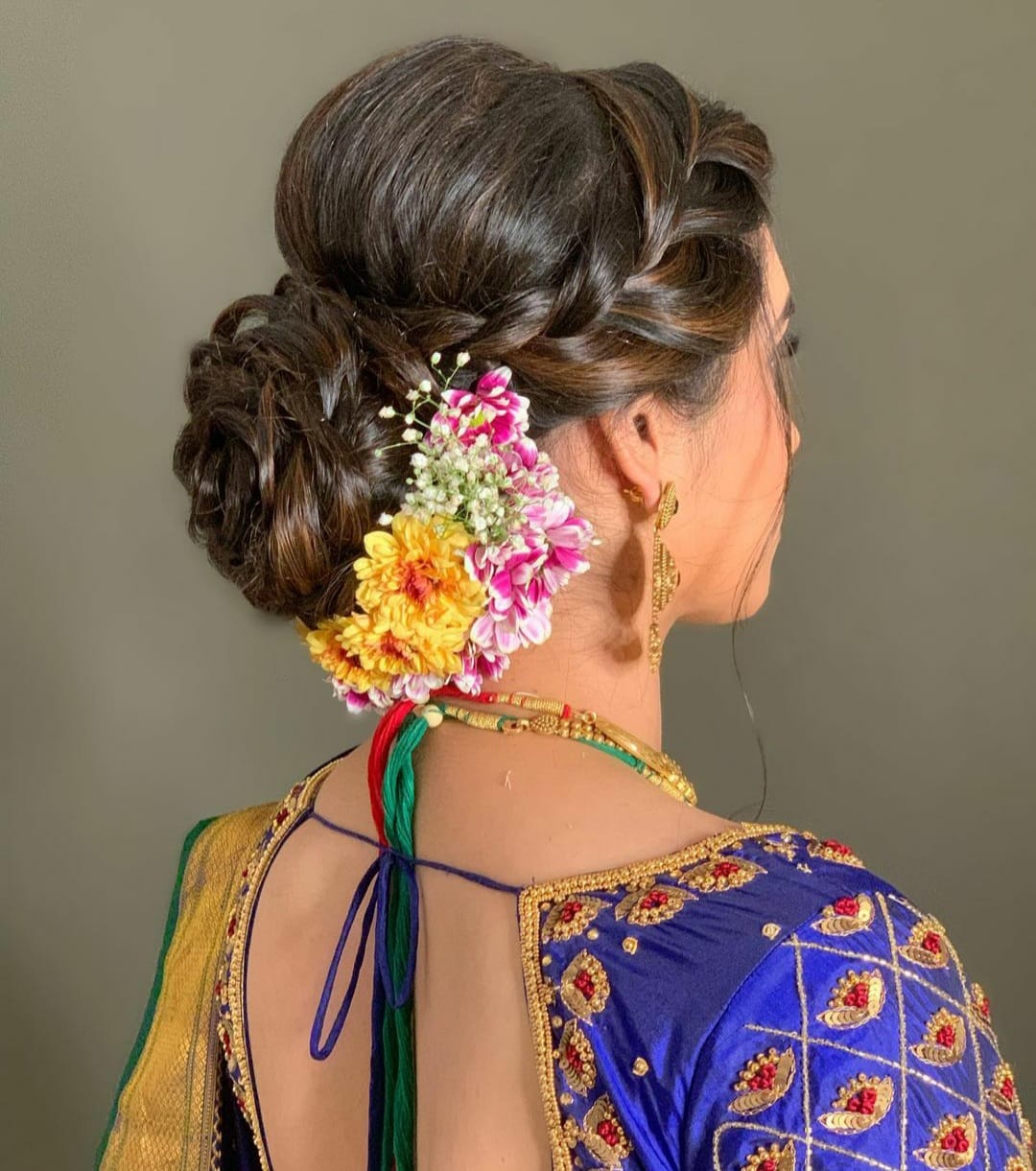 Braided bridal bun dressed with fresh flowers styled at Prayosha Salon